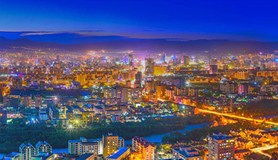 明け方の夜景のイラスト。濃い青の空にオレンジ色のネオンや道路の照明が美しく輝いています。